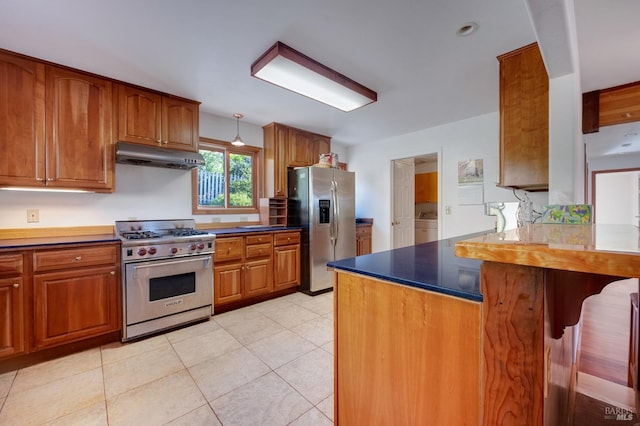 kitchen featuring stainless steel appliances, light tile patterned floors, kitchen peninsula, and washer / dryer