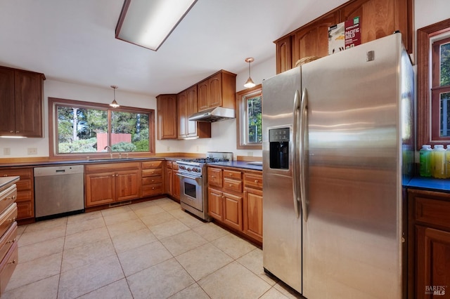 kitchen with hanging light fixtures, appliances with stainless steel finishes, sink, and light tile patterned floors