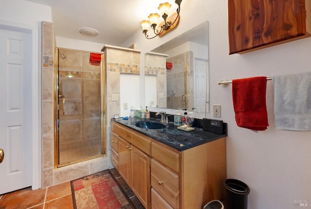 bathroom with tile patterned flooring, a shower with door, and vanity