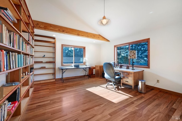 home office with hardwood / wood-style flooring and lofted ceiling with beams