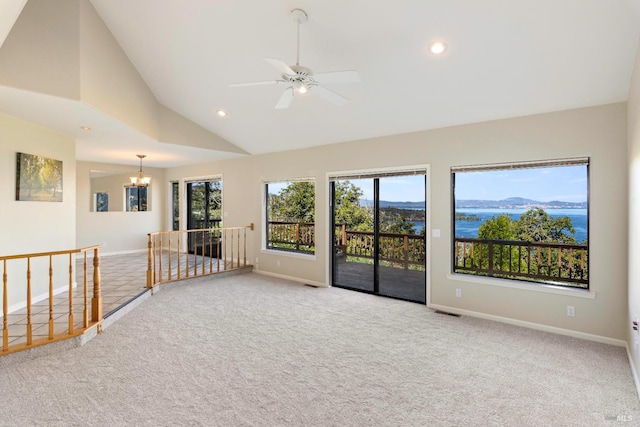 spare room featuring ceiling fan with notable chandelier, light colored carpet, high vaulted ceiling, and a mountain view