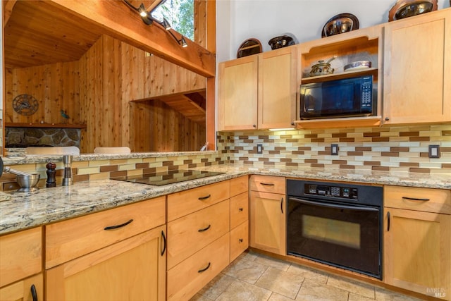 kitchen featuring light brown cabinets, black appliances, and light stone countertops