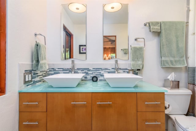 bathroom with vanity, toilet, and backsplash