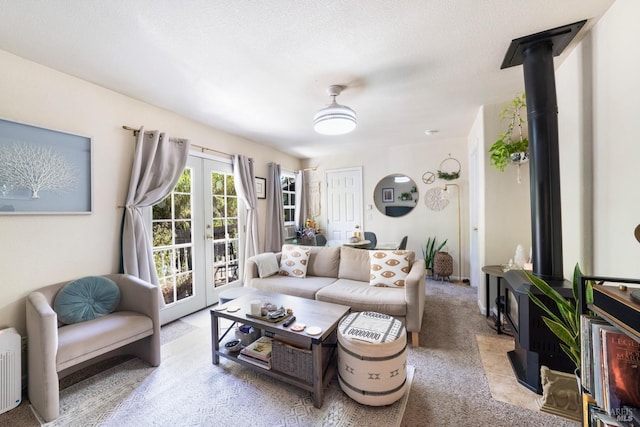 living area with carpet, a wood stove, and french doors