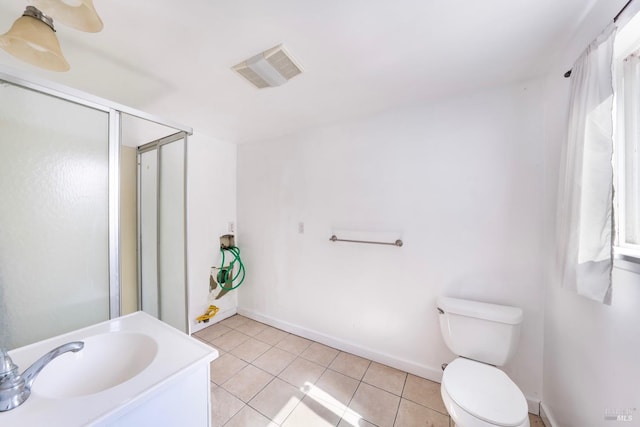 bathroom featuring tile patterned floors, vanity, toilet, and a shower with shower door