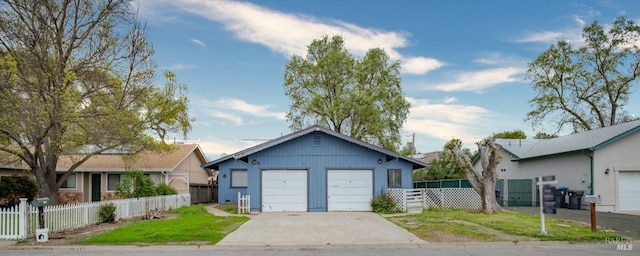 single story home featuring an outbuilding, a front lawn, and a garage