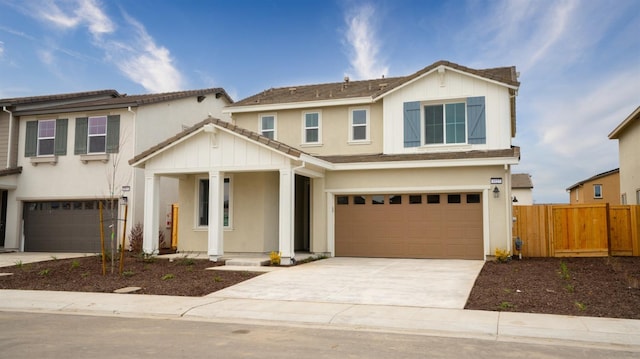 view of front of home featuring stucco siding, board and batten siding, fence, a garage, and driveway