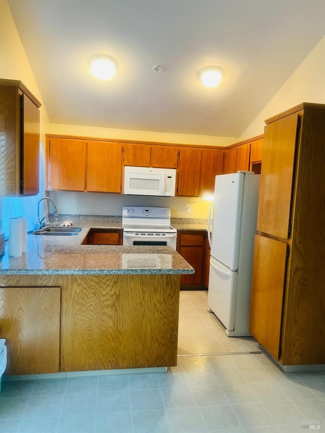 kitchen featuring white appliances, vaulted ceiling, sink, and kitchen peninsula