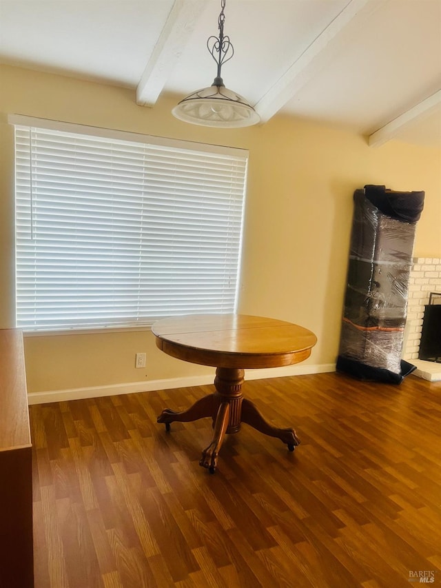 unfurnished dining area with beamed ceiling and wood-type flooring