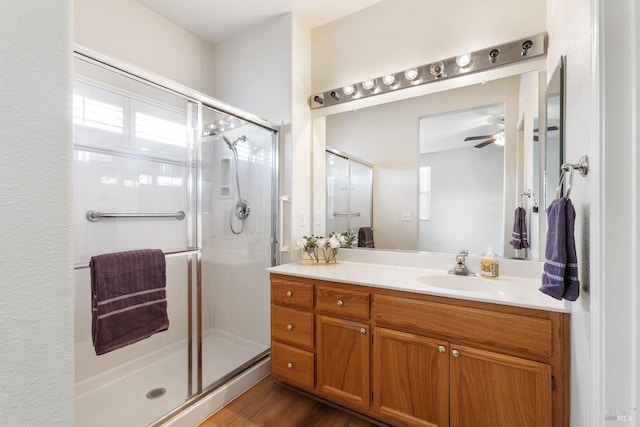 bathroom with wood-type flooring, vanity, and a shower with door