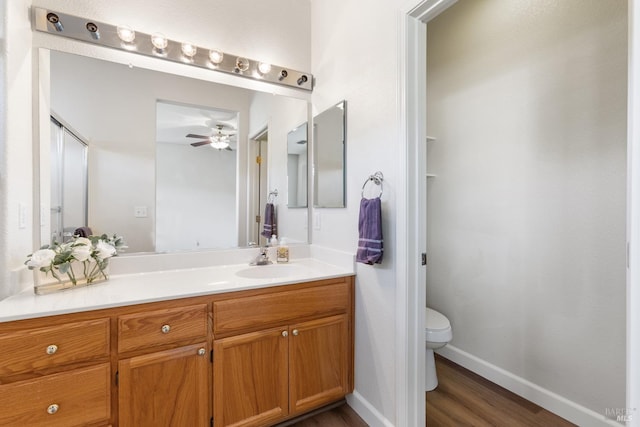 bathroom featuring ceiling fan, hardwood / wood-style flooring, vanity, and toilet