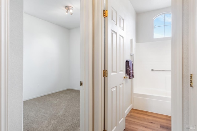 hall with light colored carpet