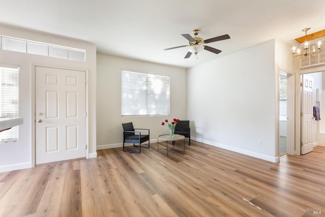 unfurnished room featuring light hardwood / wood-style floors and ceiling fan with notable chandelier