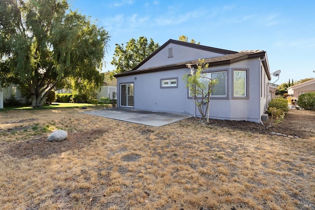 back of house with a patio and stucco siding