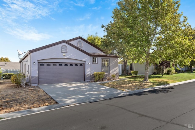 view of front of house featuring a front lawn, driveway, an attached garage, and stucco siding