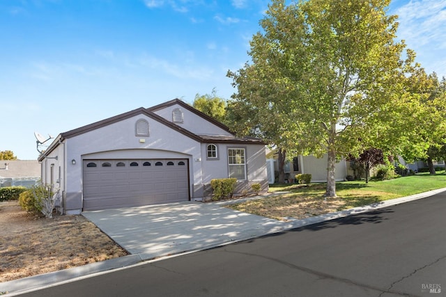 ranch-style house with a garage, driveway, a front yard, and stucco siding