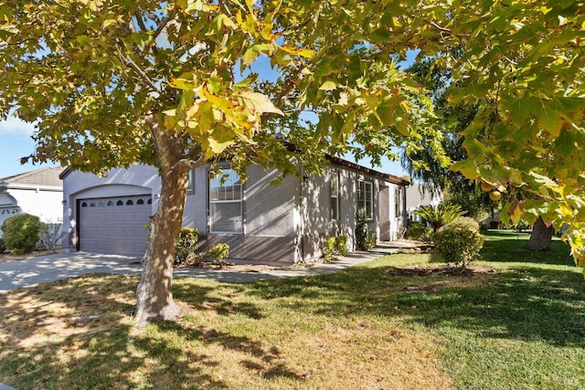 obstructed view of property with driveway, a front lawn, and an attached garage