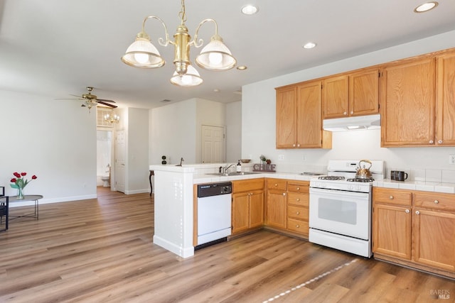 kitchen featuring white appliances, ceiling fan with notable chandelier, sink, hanging light fixtures, and light wood-type flooring