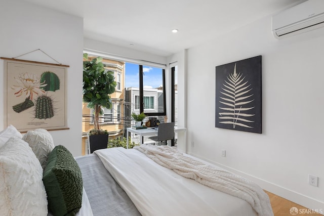 bedroom featuring wood-type flooring, an AC wall unit, and access to outside