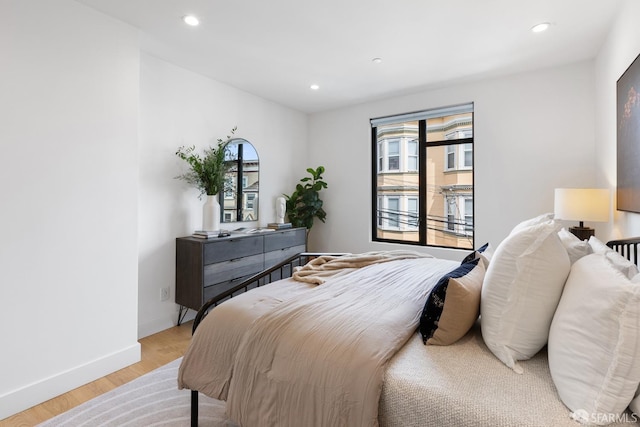 bedroom featuring multiple windows and light hardwood / wood-style flooring