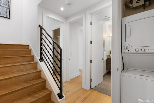 stairway featuring stacked washer and dryer and hardwood / wood-style floors