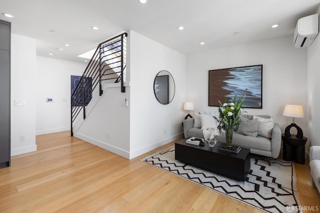 living room with light hardwood / wood-style flooring and a wall mounted AC