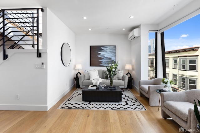 living room featuring light hardwood / wood-style flooring and an AC wall unit