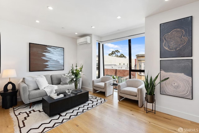 living room with a wall mounted air conditioner and light wood-type flooring