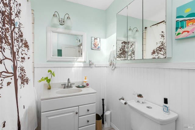 bathroom with wooden walls, vanity, and toilet