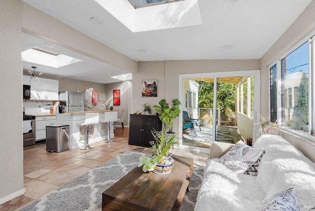 tiled living room featuring a skylight