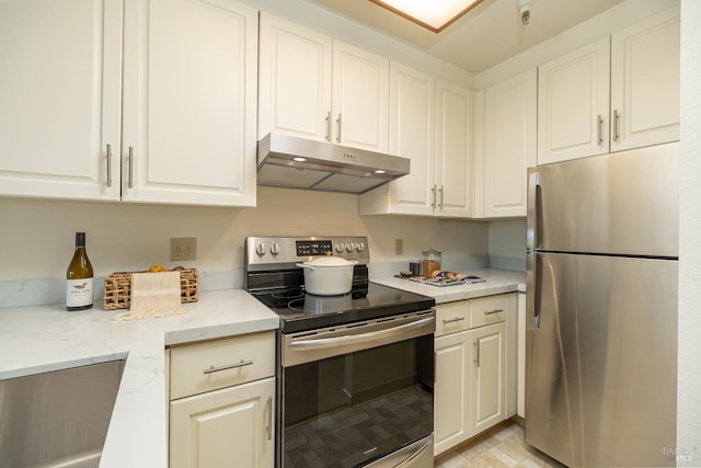 kitchen with white cabinetry, light stone countertops, and stainless steel appliances