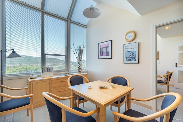 carpeted dining area featuring lofted ceiling