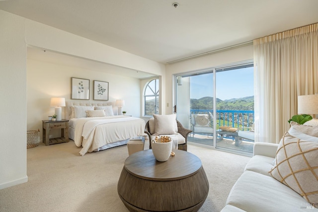 carpeted bedroom with a mountain view and access to exterior