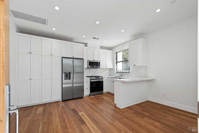 kitchen featuring light stone counters, white cabinets, sink, dark wood-type flooring, and appliances with stainless steel finishes