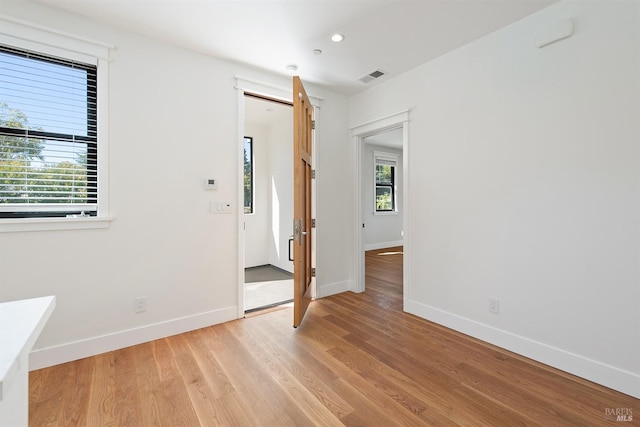 empty room with a healthy amount of sunlight and light hardwood / wood-style floors