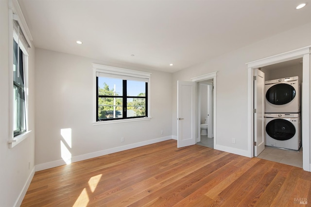 interior space with stacked washer and dryer and light hardwood / wood-style flooring