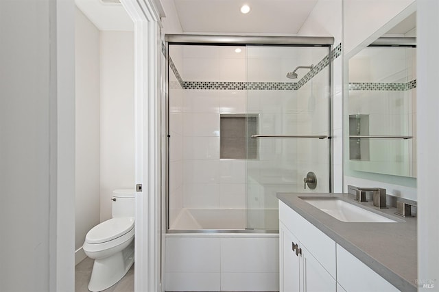 full bathroom with bath / shower combo with glass door, tile patterned floors, vanity, and toilet