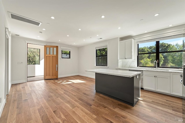 kitchen with plenty of natural light, white cabinets, and a kitchen island