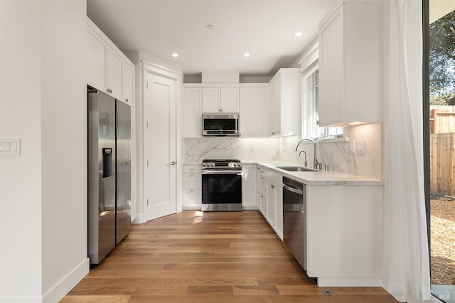 kitchen with a healthy amount of sunlight, sink, stainless steel appliances, and white cabinets