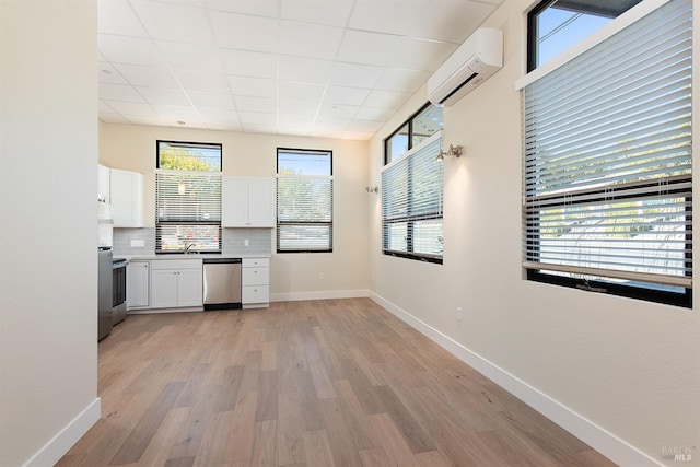 kitchen with an AC wall unit, a healthy amount of sunlight, and backsplash