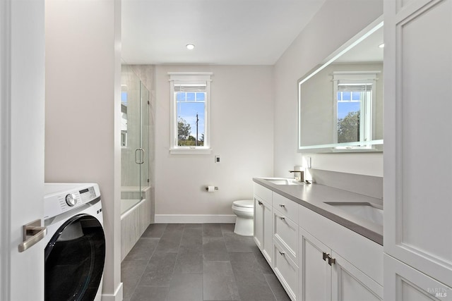 bathroom with a healthy amount of sunlight, vanity, toilet, and washer / dryer