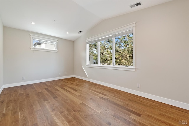 unfurnished room featuring lofted ceiling and light hardwood / wood-style floors