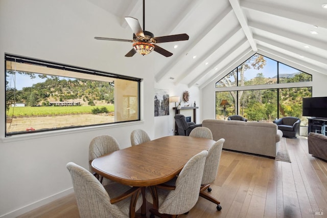 dining room with vaulted ceiling with beams, light hardwood / wood-style flooring, a wealth of natural light, and ceiling fan