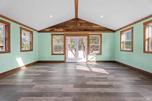 unfurnished living room with lofted ceiling, a healthy amount of sunlight, dark hardwood / wood-style flooring, and french doors