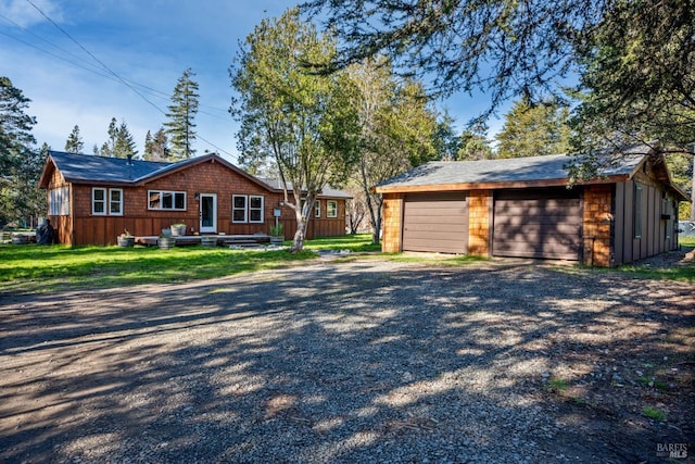 view of front of home with a garage, an outdoor structure, and a front yard