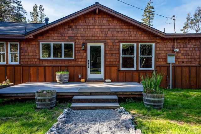 back of house with a wooden deck and a yard