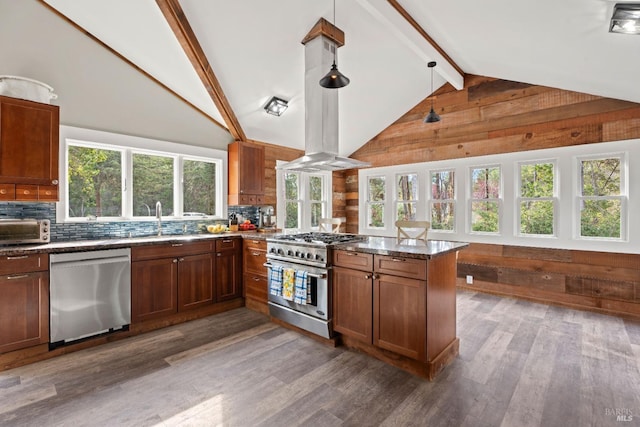 kitchen featuring appliances with stainless steel finishes, decorative light fixtures, lofted ceiling with beams, decorative backsplash, and kitchen peninsula