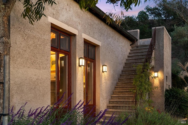 view of property exterior with stairs and stucco siding