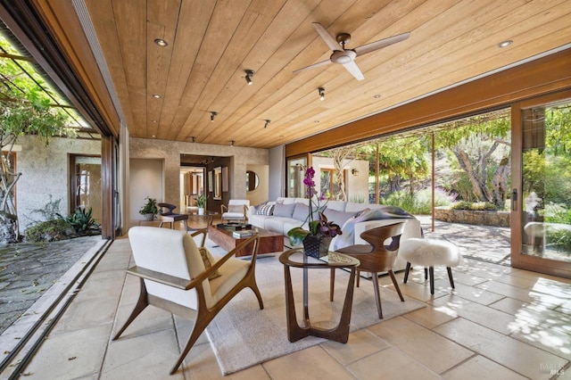 sunroom / solarium featuring wooden ceiling and a ceiling fan