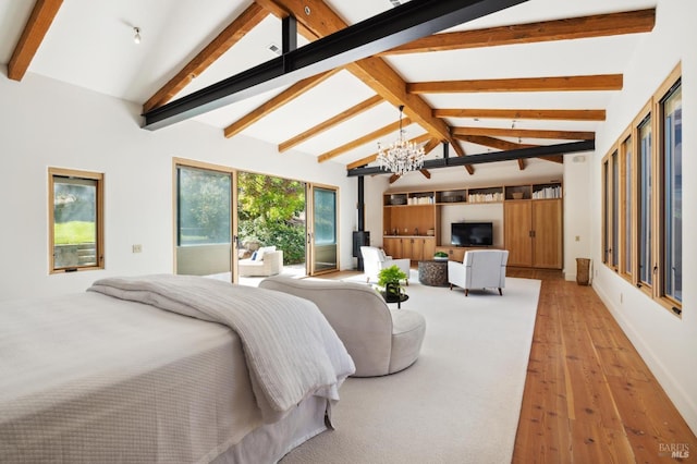 bedroom with light wood finished floors, a chandelier, beamed ceiling, a wood stove, and access to outside